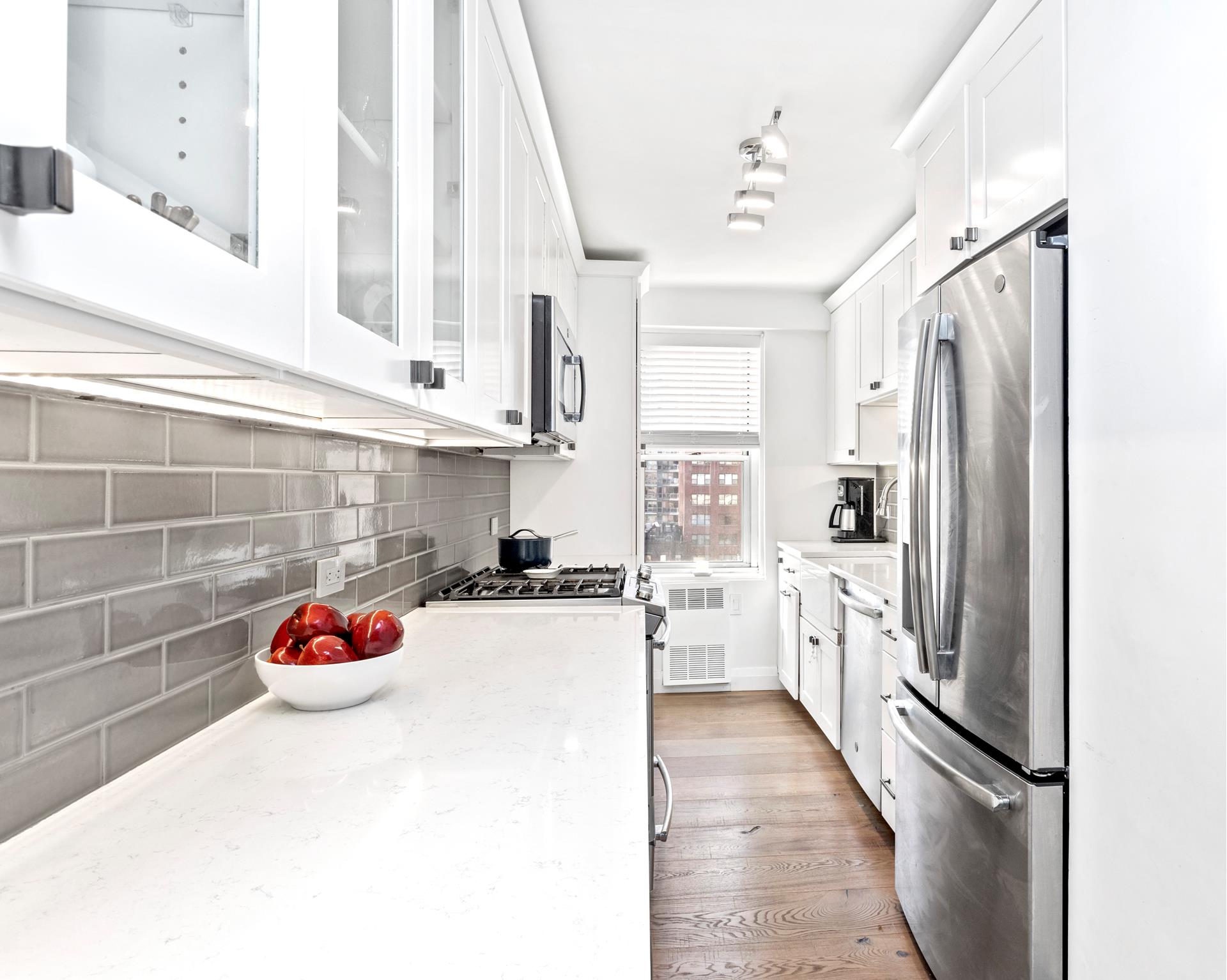 a kitchen with a refrigerator and white cabinets