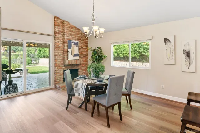 a dining room with furniture a chandelier and wooden floor