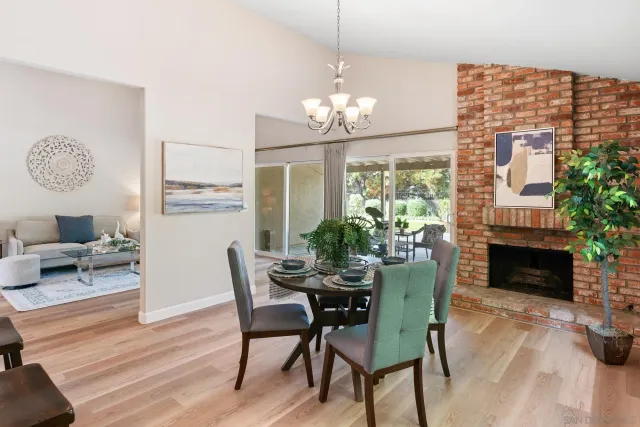 a dining room with furniture a fireplace and wooden floor