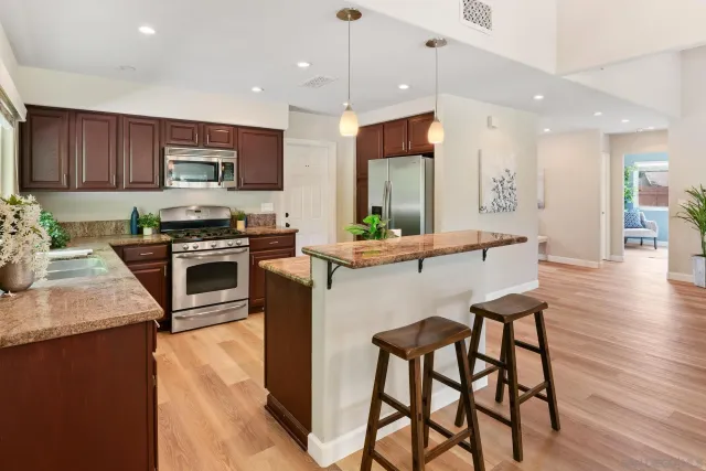 a kitchen with stainless steel appliances kitchen island granite countertop a stove a sink and a microwave