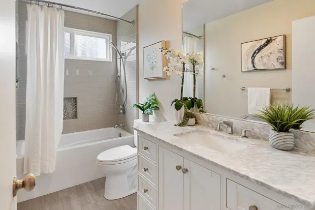 a bathroom with a granite countertop sink a toilet and a large mirror