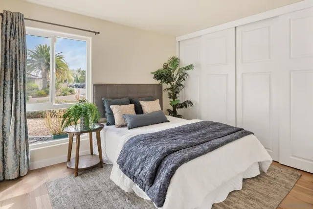 a bedroom with a bed and a potted plant