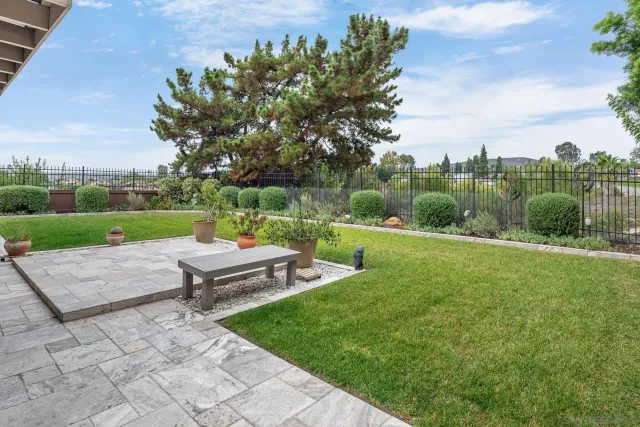 a green field with lots of trees in the background