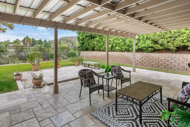 a view of a patio with a table and chairs under an umbrella