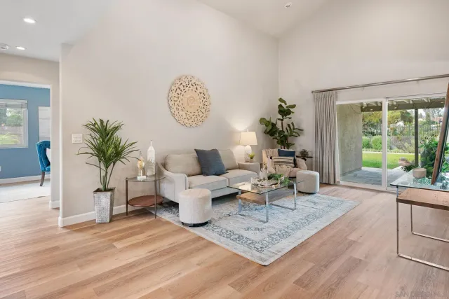 a living room with furniture potted plant and a large window
