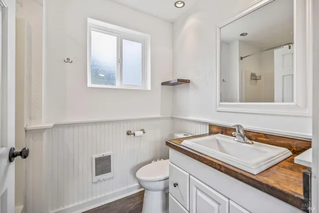 a bathroom with a sink a toilet and a mirror