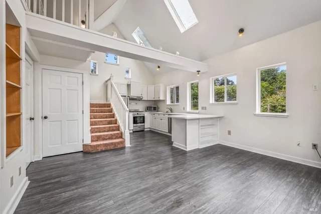 a view of a kitchen with stairs and wooden floor