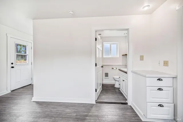 a view of a hallway with wooden floor and closet