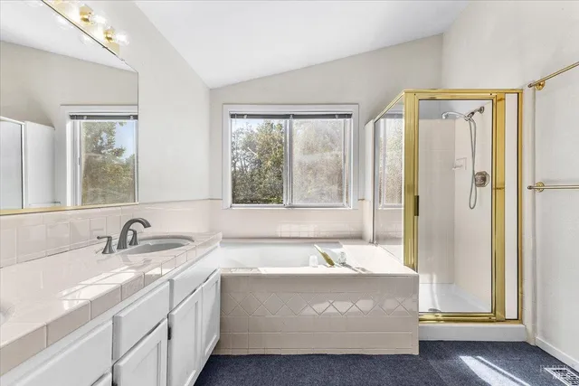 a bathroom with a tub a sink and a window