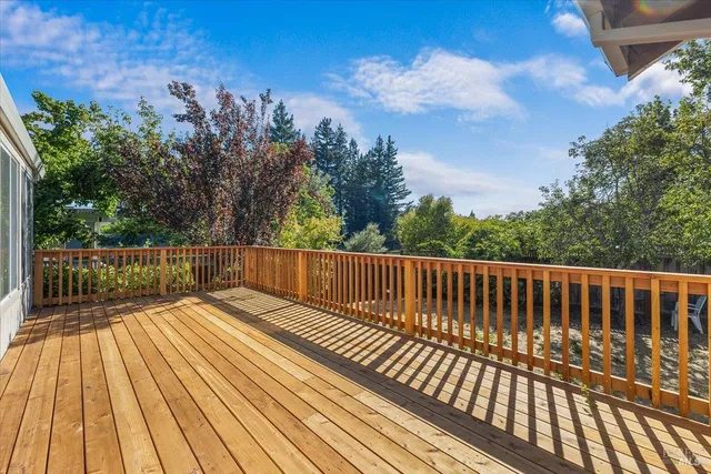 a view of balcony with wooden floor and fence