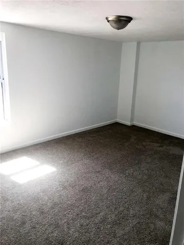 an empty room with a window and a ceiling fan