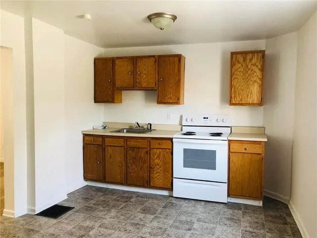 a kitchen with sink a stove and cabinets
