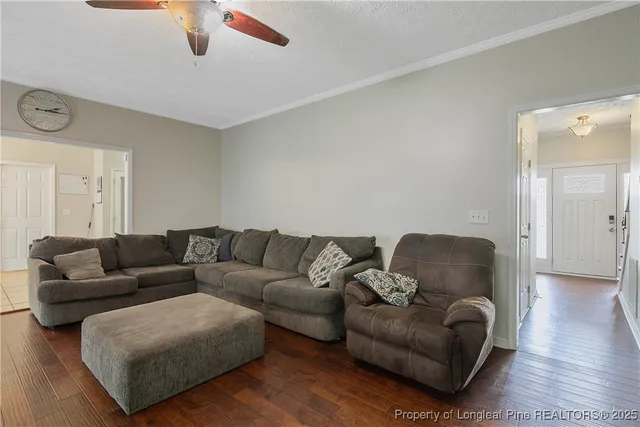 a living room with furniture and a ceiling fan