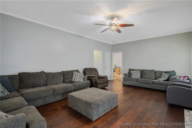 a living room with furniture and a wooden floor