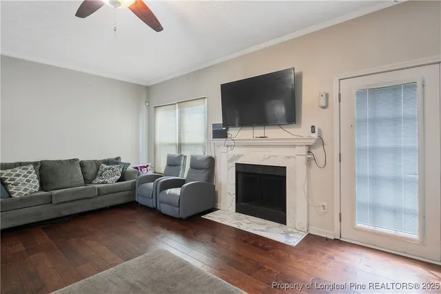 a living room with furniture a flat screen tv and a fireplace