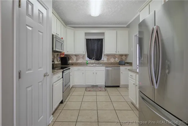 a kitchen with a refrigerator sink and cabinets