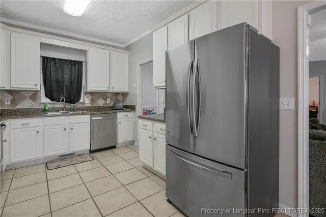 a kitchen with stainless steel appliances a refrigerator sink and cabinets