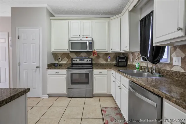 a kitchen with appliances a sink and cabinets