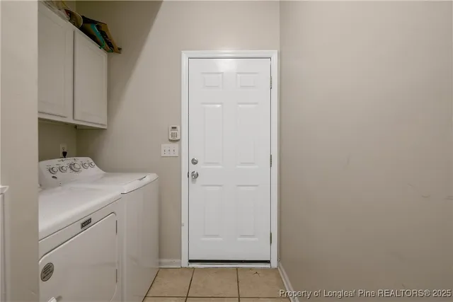 a utility room with cabinets washer and dryer