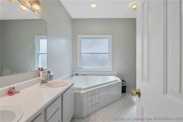 a bathroom with a tub sink and mirror