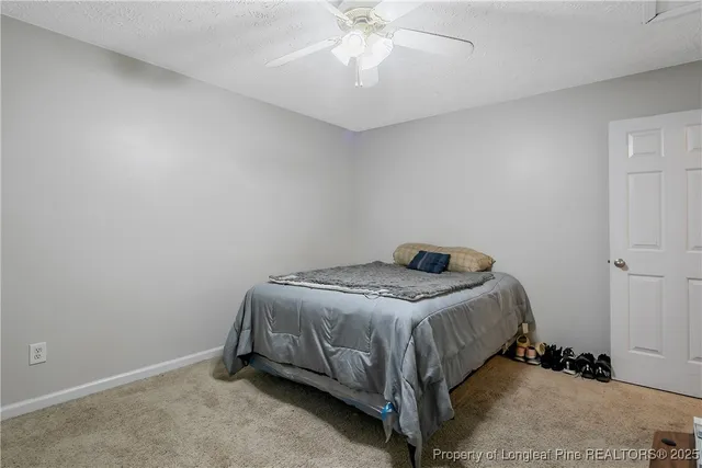a bedroom with a bed and a chandelier fan