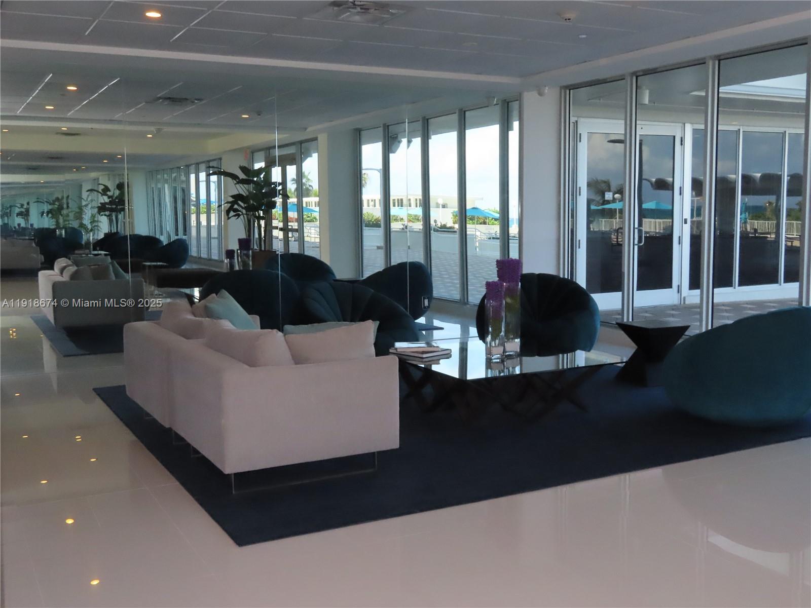 5701 Collins Avenue, Unit 808 Miami Beach, FL 33140 - Photo 27 of 40 a living room with furniture and floor to ceiling windows