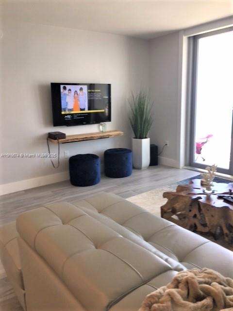5701 Collins Avenue, Unit 808 Miami Beach, FL 33140 - Photo 8 of 40 a living room with furniture and a flat screen tv