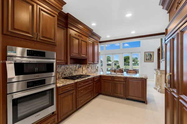 a kitchen with stainless steel appliances granite countertop wooden cabinets and a stove top oven
