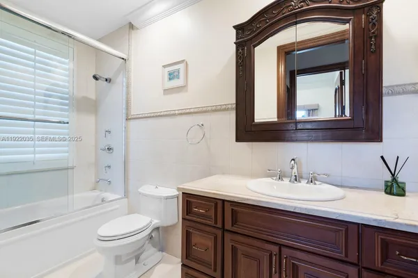 a bathroom with a sink vanity toilet and shower
