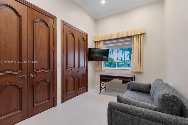 a living room with furniture a window and a flat screen tv