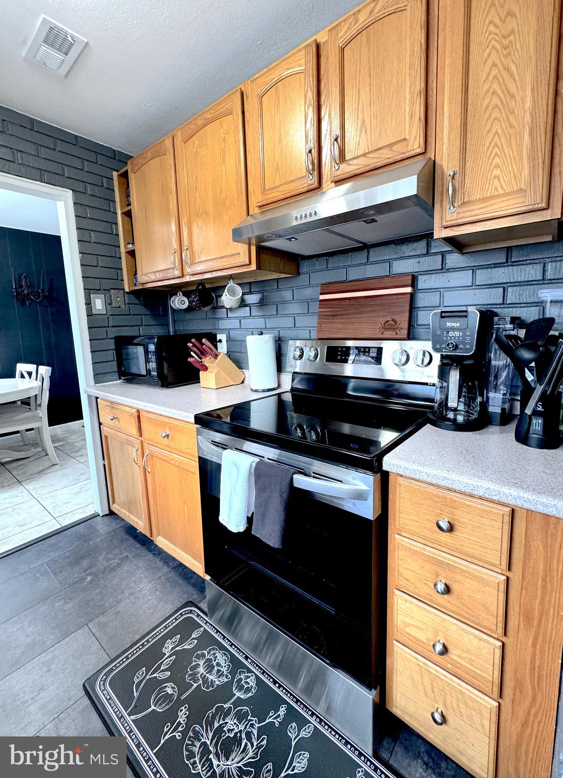1046 Thomas Road Glen Burnie, MD 21060 - Photo 12 of 30 a kitchen with stainless steel appliances granite countertop a stove a sink and a microwave