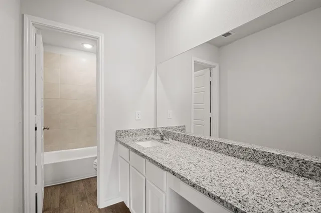 a bathroom with a granite countertop sink and a mirror