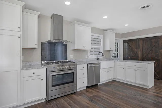a kitchen with granite countertop white cabinets and white stove