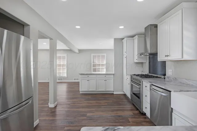 a kitchen with stainless steel appliances granite countertop a refrigerator and a stove top oven