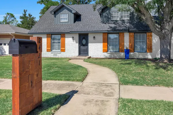 a front view of a house with a yard and trees