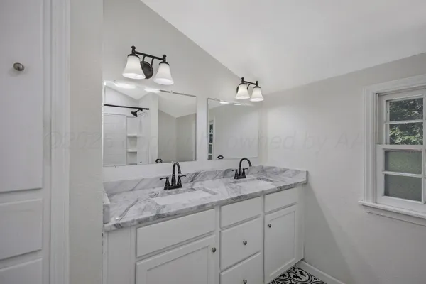 a bathroom with a granite countertop sink and a mirror