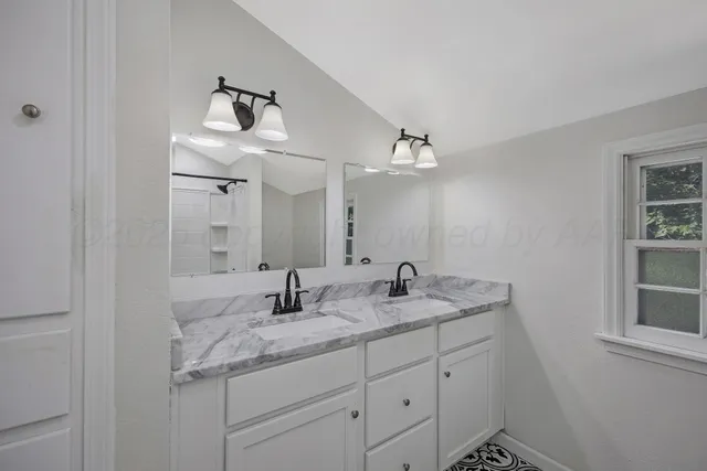 a bathroom with a granite countertop sink and a mirror