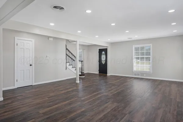 an empty room with wooden floor and window