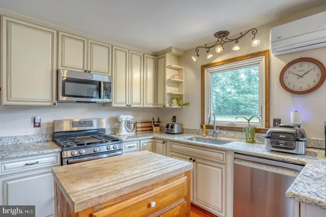 a kitchen with stainless steel appliances granite countertop a refrigerator stove top oven and sink
