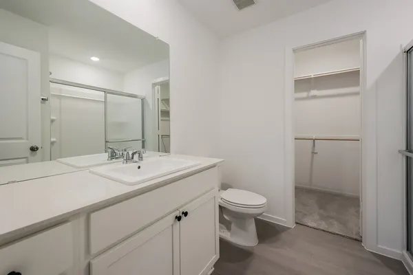a bathroom with a granite countertop sink a toilet and a mirror