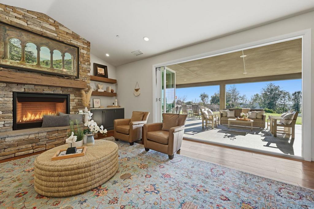 2263 Corner Creek Lane Fallbrook, CA 92028 - Photo 19 of 73 a living room with furniture a fireplace and a large window