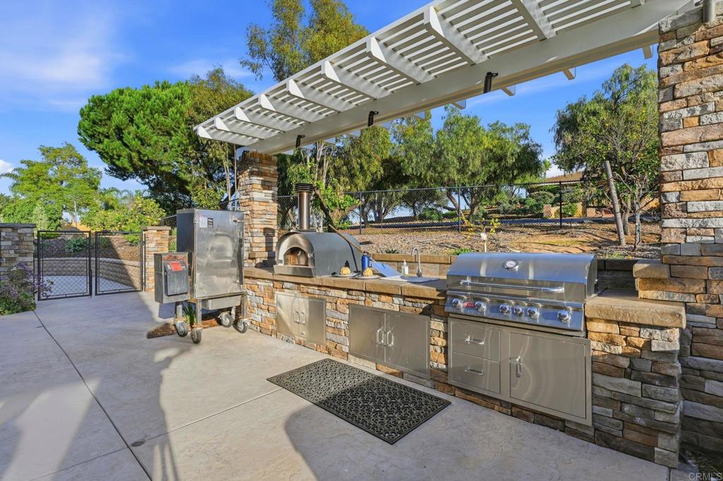2263 Corner Creek Lane Fallbrook, CA 92028 - Photo 49 of 73 a view of a patio with table and chairs with wooden floor and fence