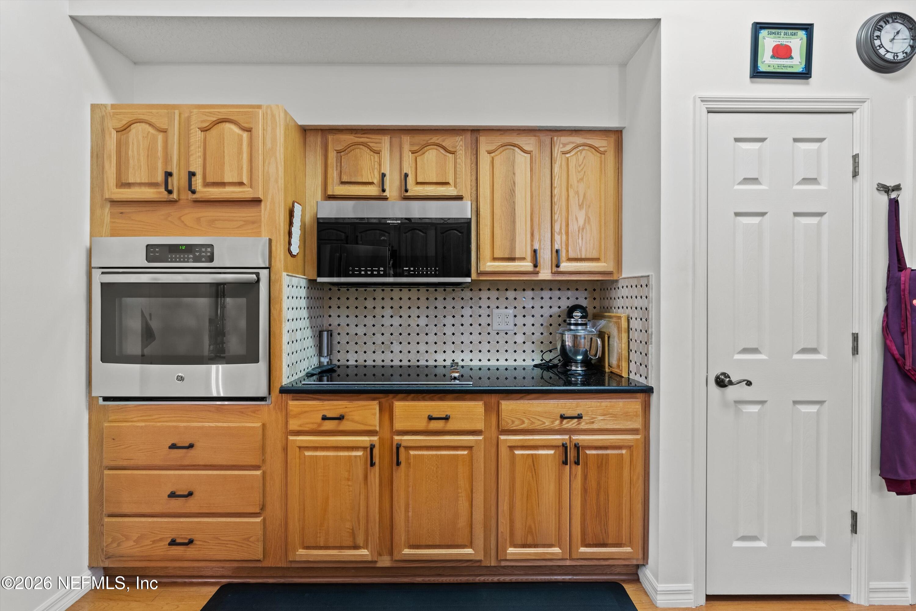 5566 Don Manuel Road Elkton, FL 32033 - Photo 17 of 47 a kitchen with granite countertop cabinets stainless steel appliances and a wooden floor