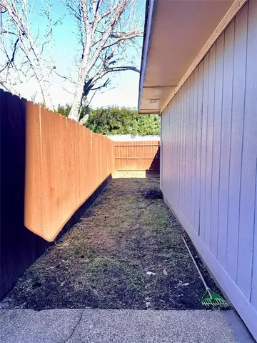 a view of a backyard with wooden fence