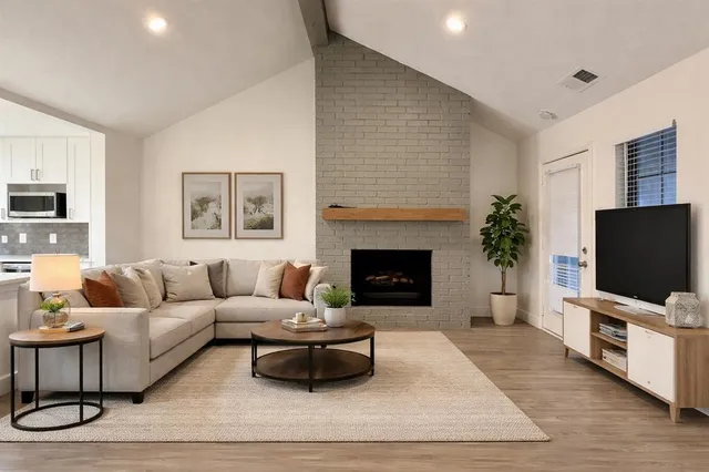 a living room with furniture a flat screen tv and a fireplace