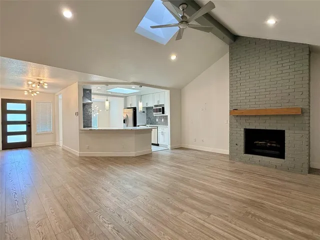 a view of a room with wooden floor and a fireplace
