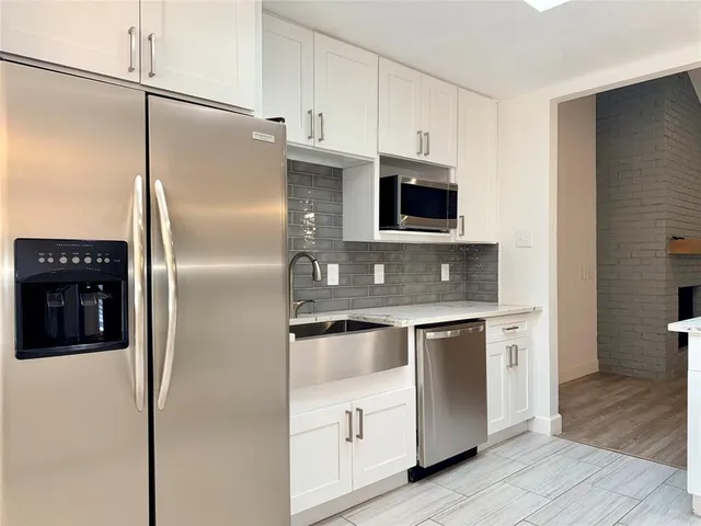 a kitchen with stainless steel appliances granite countertop a refrigerator a stove and a microwave