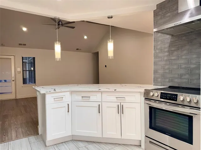 a kitchen with granite countertop white cabinets and white appliances