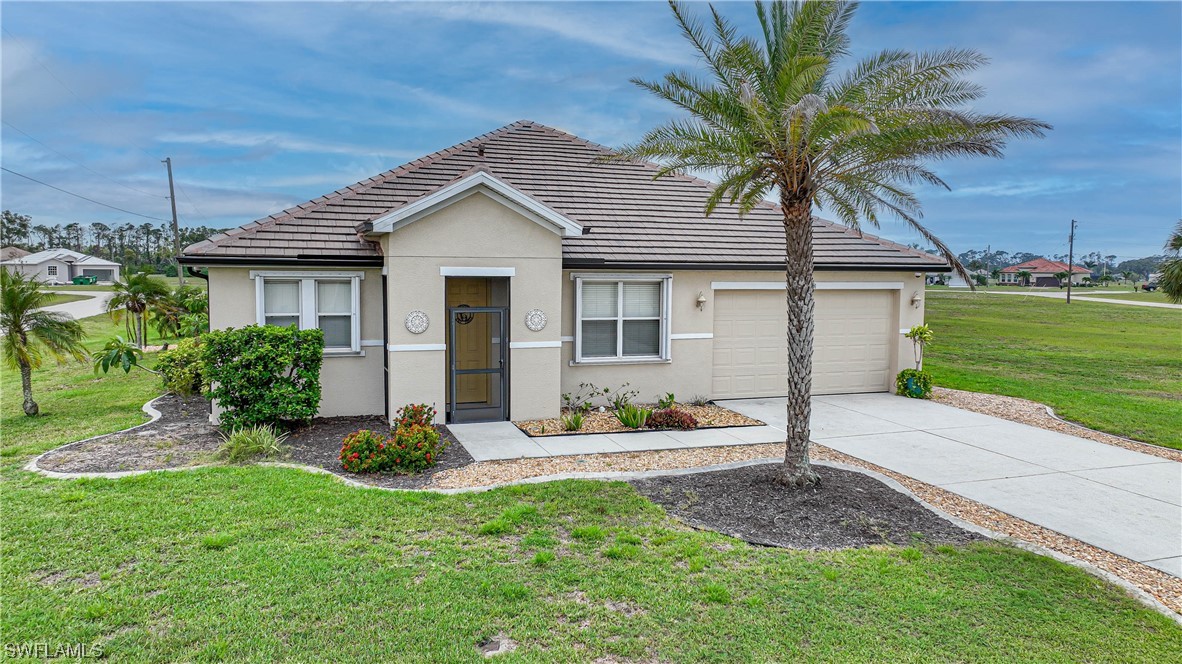 24501 Cabana Road Punta Gorda, FL 33955 - Photo 1 of 39 a front view of a house with a garden and yard