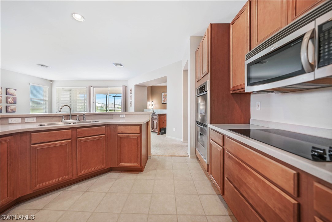 24501 Cabana Road Punta Gorda, FL 33955 - Photo 10 of 39 a kitchen with stainless steel appliances granite countertop a sink and dishwasher a stove top oven with wooden floor
